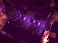 Nahaufnahme eines optischen Geräts, beleuchtet in lila Licht.