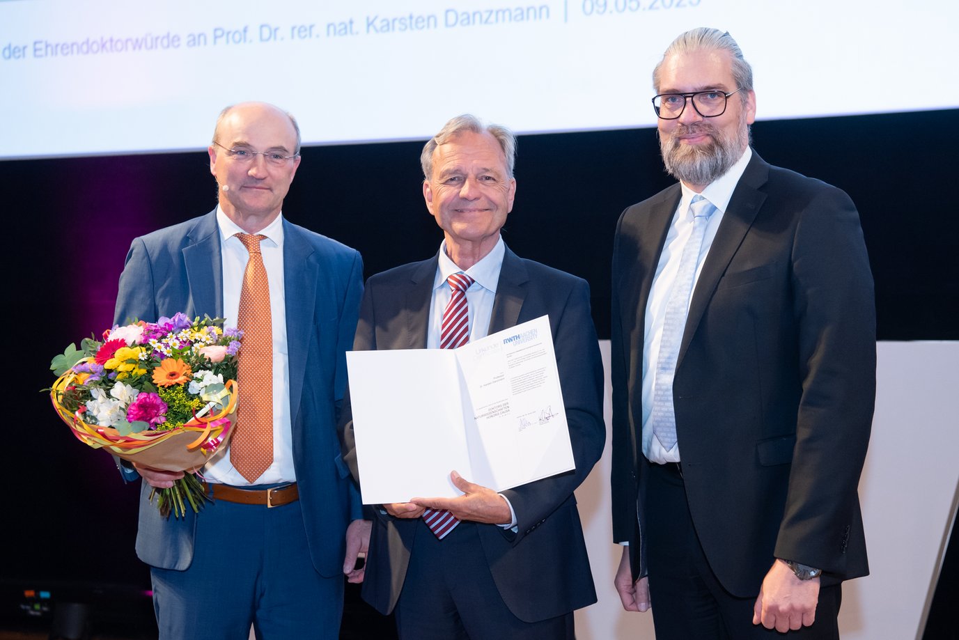 Karsten Danzmann (Mitte) erhält die Urkunde seiner Ehrendoktorwürde von Rektor Professor Ulrich Rüdiger (links) und Professor Kai-Uwe Schröder, Senatsvorsitzender der RWTH.