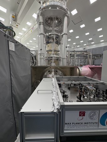 The laser lightsource from Hannover (bottom right) and the optical resonator, a light storage device, in one of the ETpathfinder vacuum tanks (middle). Photo from inside a laboratory with complex technical devices and machines.