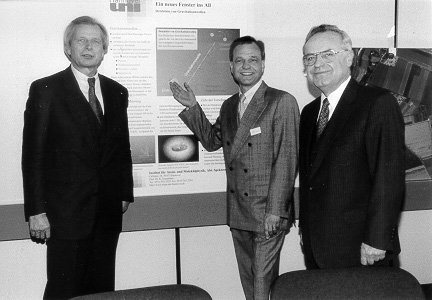 Dr. Ahrens, Prof. Danzmann, and Prof. Walther in front of the GEO600 posters.