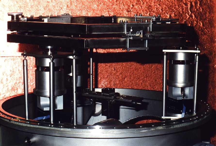 The hexagonal top plate lies on the active/passive seismic isolation stacks; above the top plate the rotational stage.
