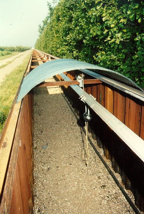 READY! You can see a part of the roof that will cover the trench. Attached to the rail you can see the trolley for pushing the tube out of the end house. The black wheel connected to the trolley takes the rope where the tube will rest in. That way the whole tube can be rotated around it's axis. In the trench on the right hand side you see the power supply cable running to the central station.