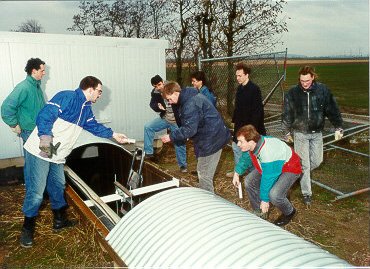 Outside the central building. The crew has uncovered the trench in order to install the suspension for the tube.